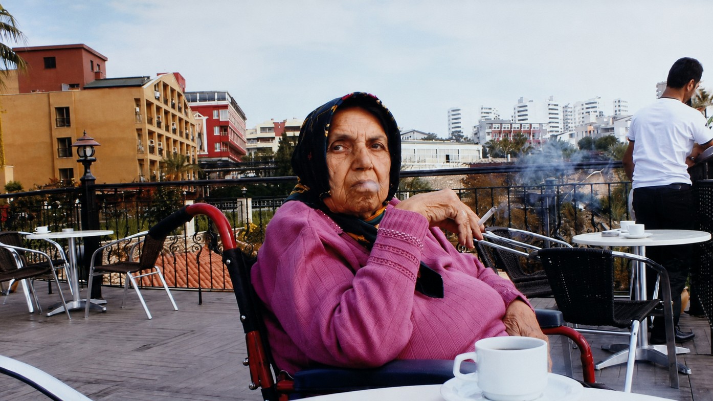 Portrait of Mother Begum later in life, seated outdoors.